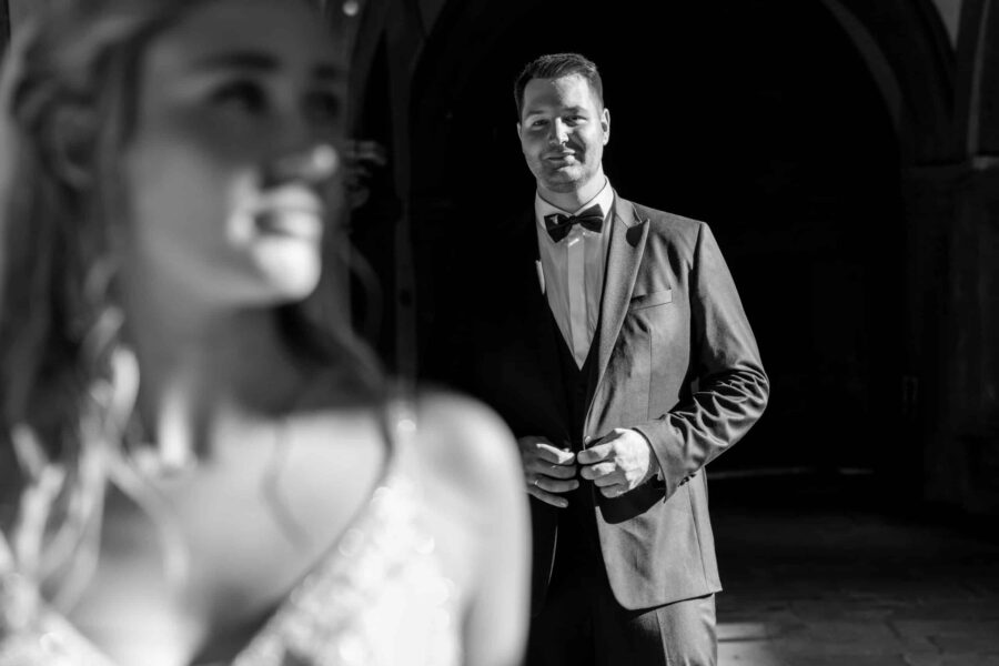 Bräutigam in Anzug, Braut unscharf im Vordergrund