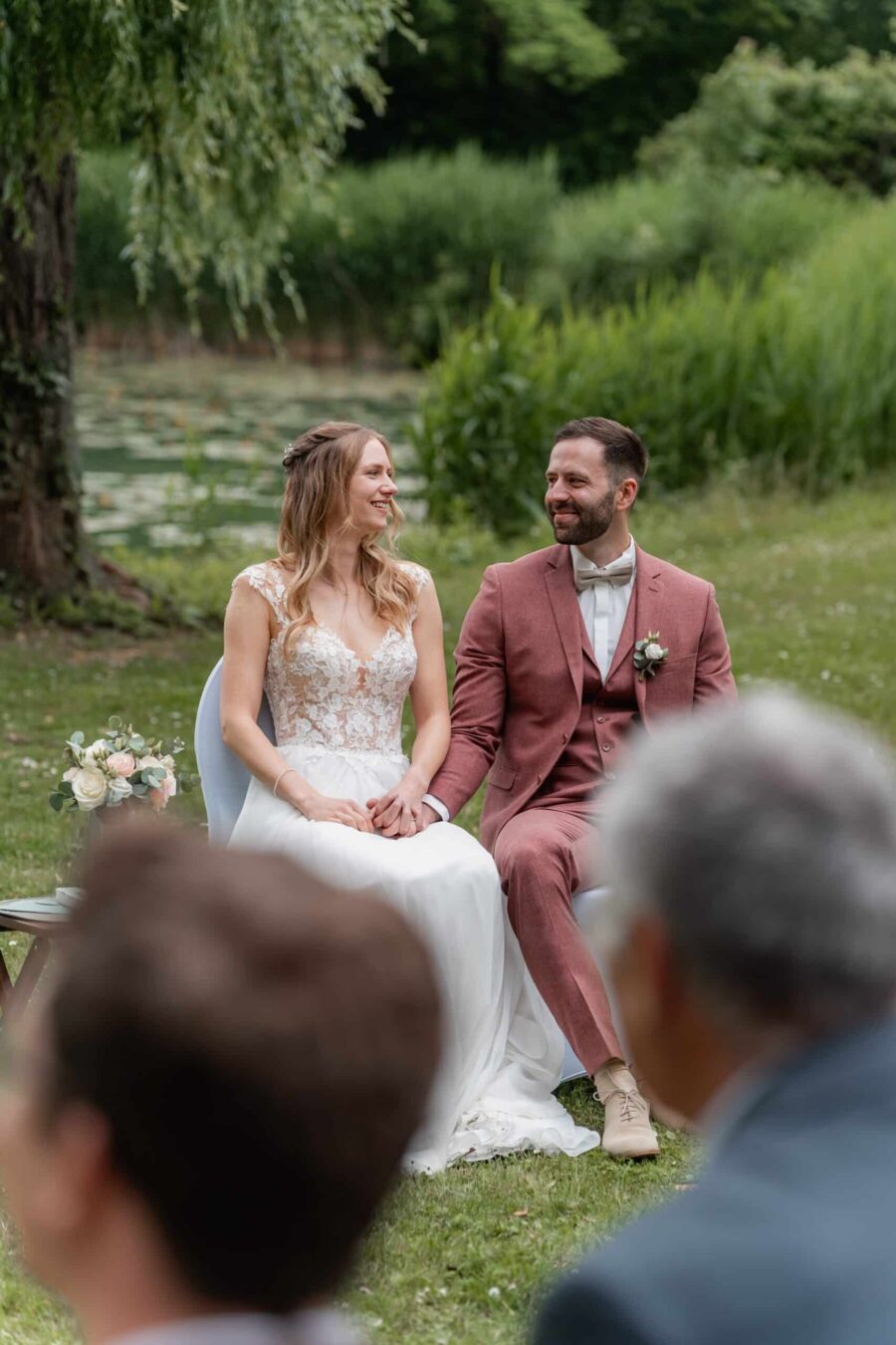 Brautpaar im Garten vor grünem Teich