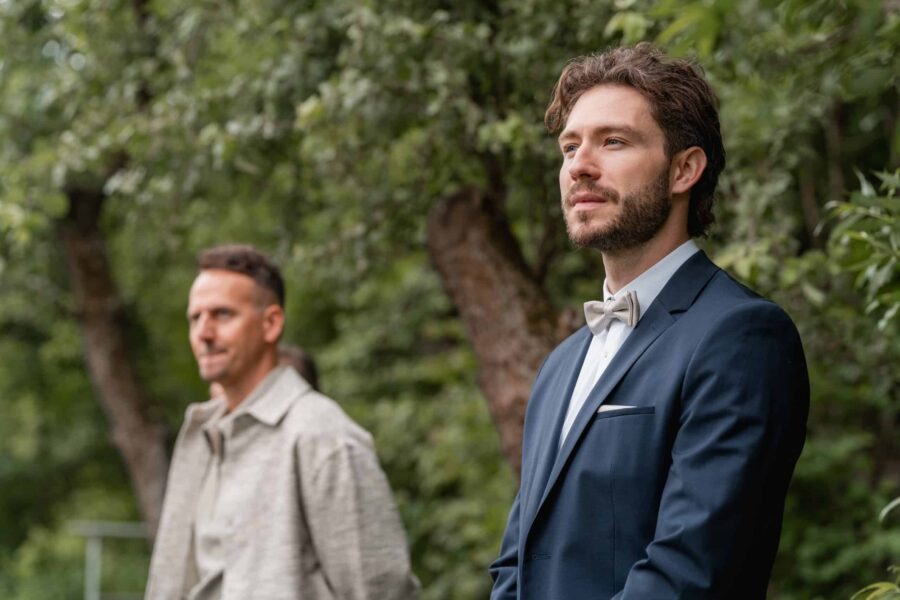 Groom wartet im Garten vor der Trauung.