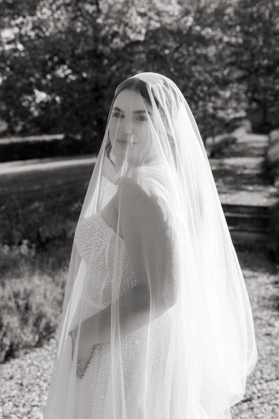Braut im weißen Schleier im Garten