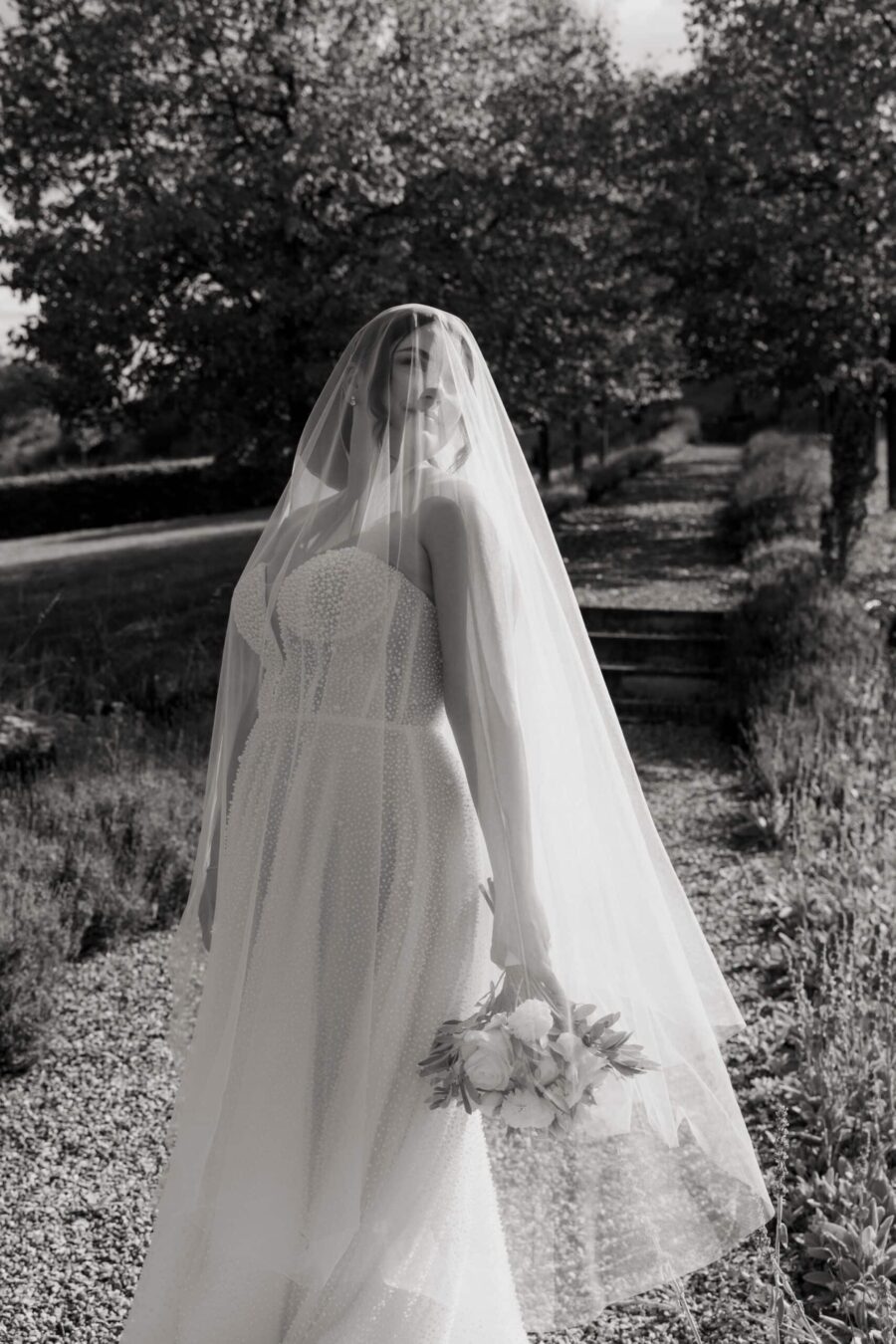 Braut mit Schleier im Garten.