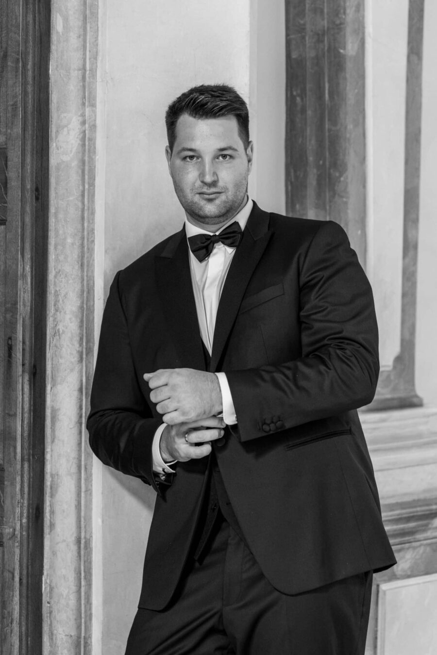 Bräutigam im eleganten Anzug an einer Steinmauer