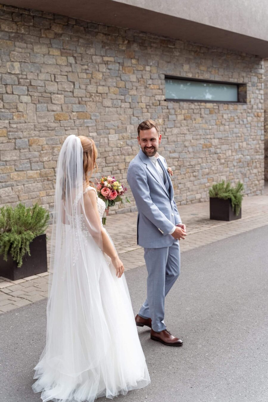 Hochzeit Steinburg Würzburg | Editorial Style & Party | Florian Knusper 32 Brautpaar im Garten mit Steinmauer im Hintergrund