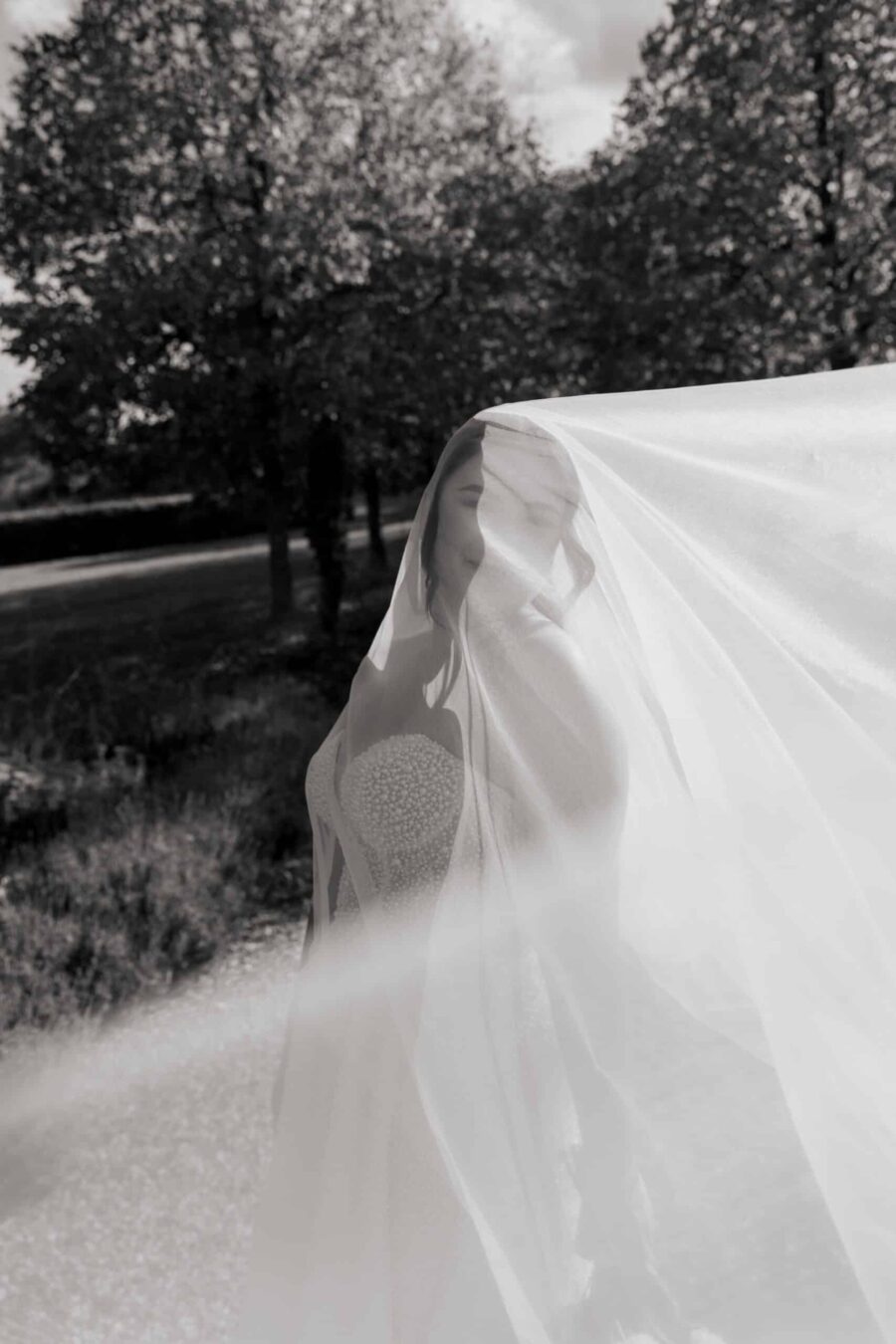 Braut im Garten mit wehendem Schleier