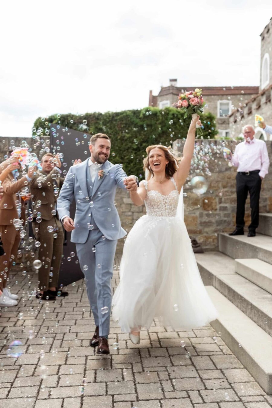 Hochzeit Steinburg Würzburg | Editorial Style & Party | Florian Knusper 129 Brautpaar beim Auszug mit Seifenblasen