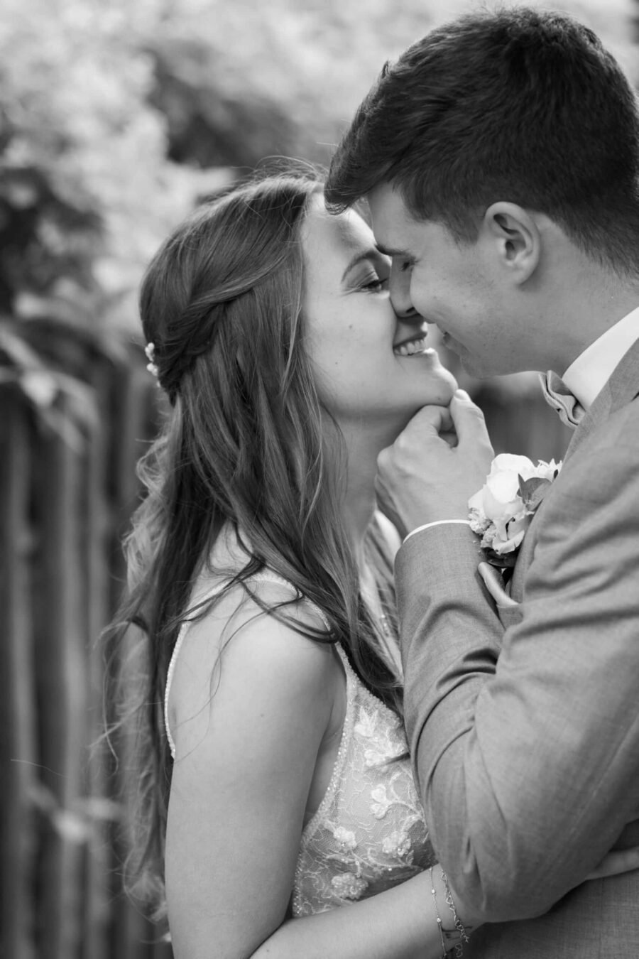 Brautpaar in inniger Umarmung im Garten.