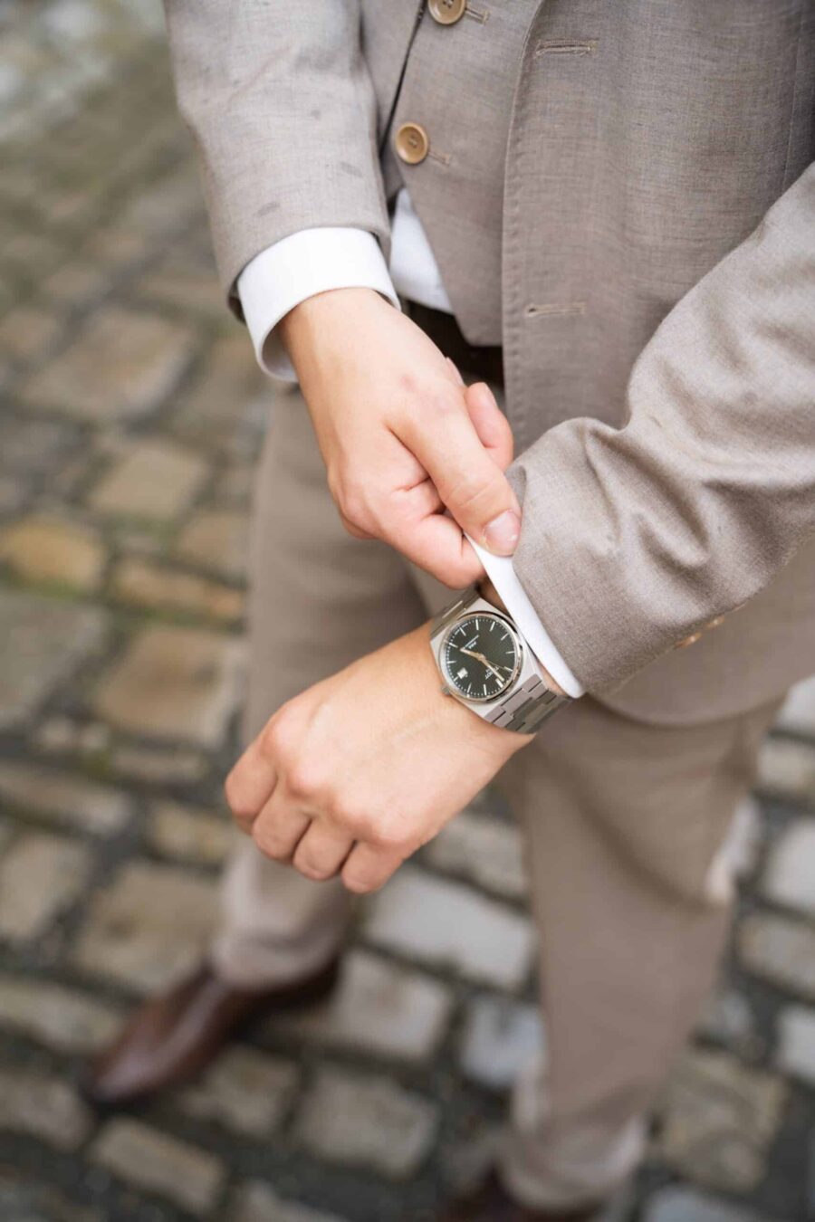 Bräutigam richtet Anzug im Innenhof.