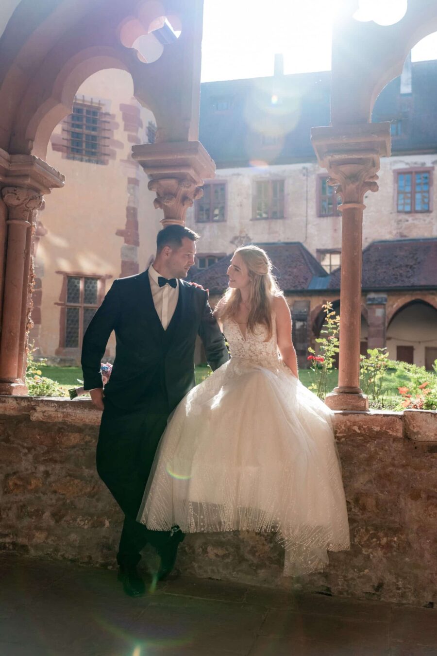 Brautpaar posiert im sonnigen Klostergarten