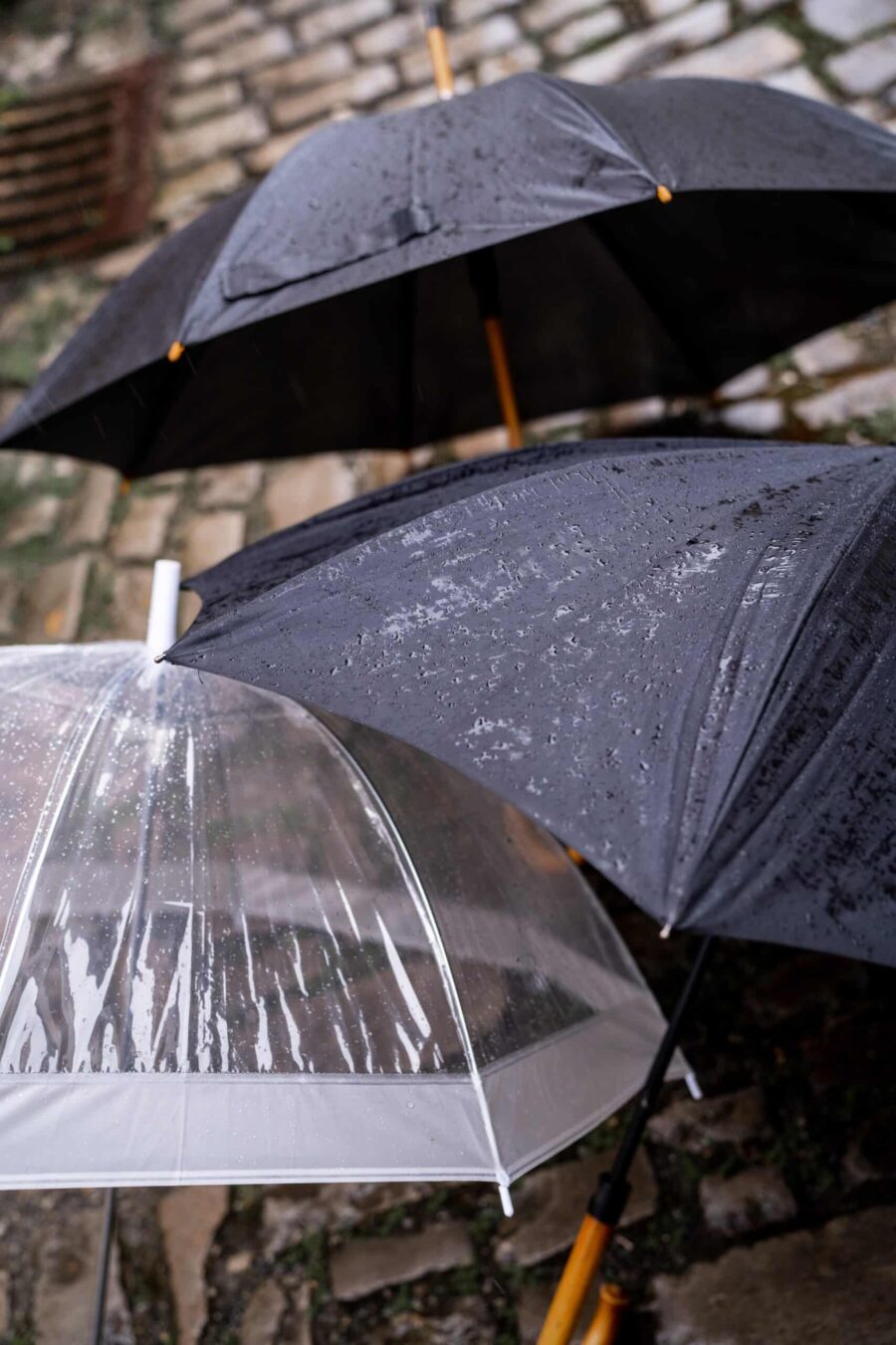 Regenschirme bei verregneter Hochzeit im Freien.
