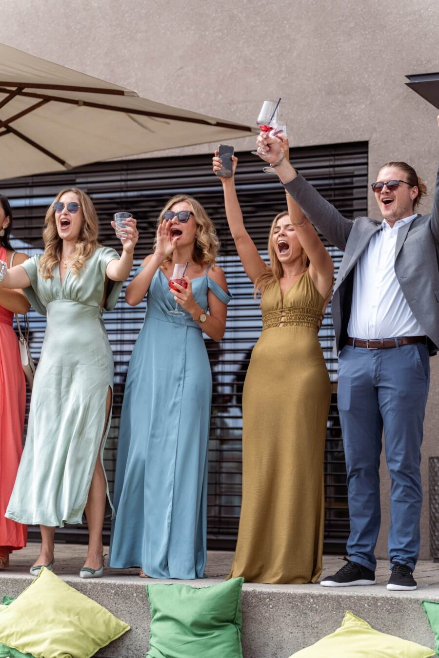 Hochzeitsparty mit feiernden Gästen im Freien.