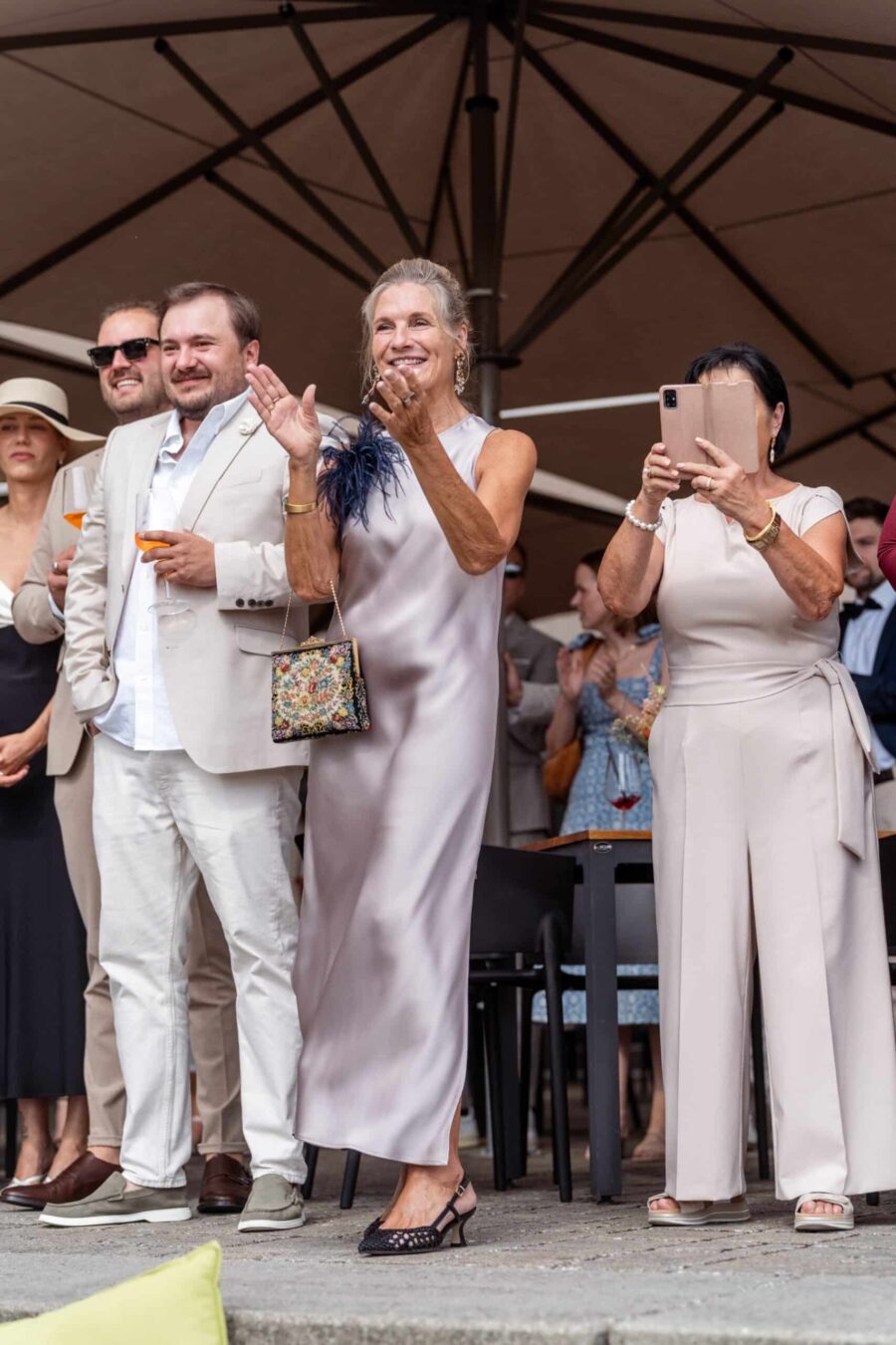Gäste applaudieren bei Hochzeit im Freien