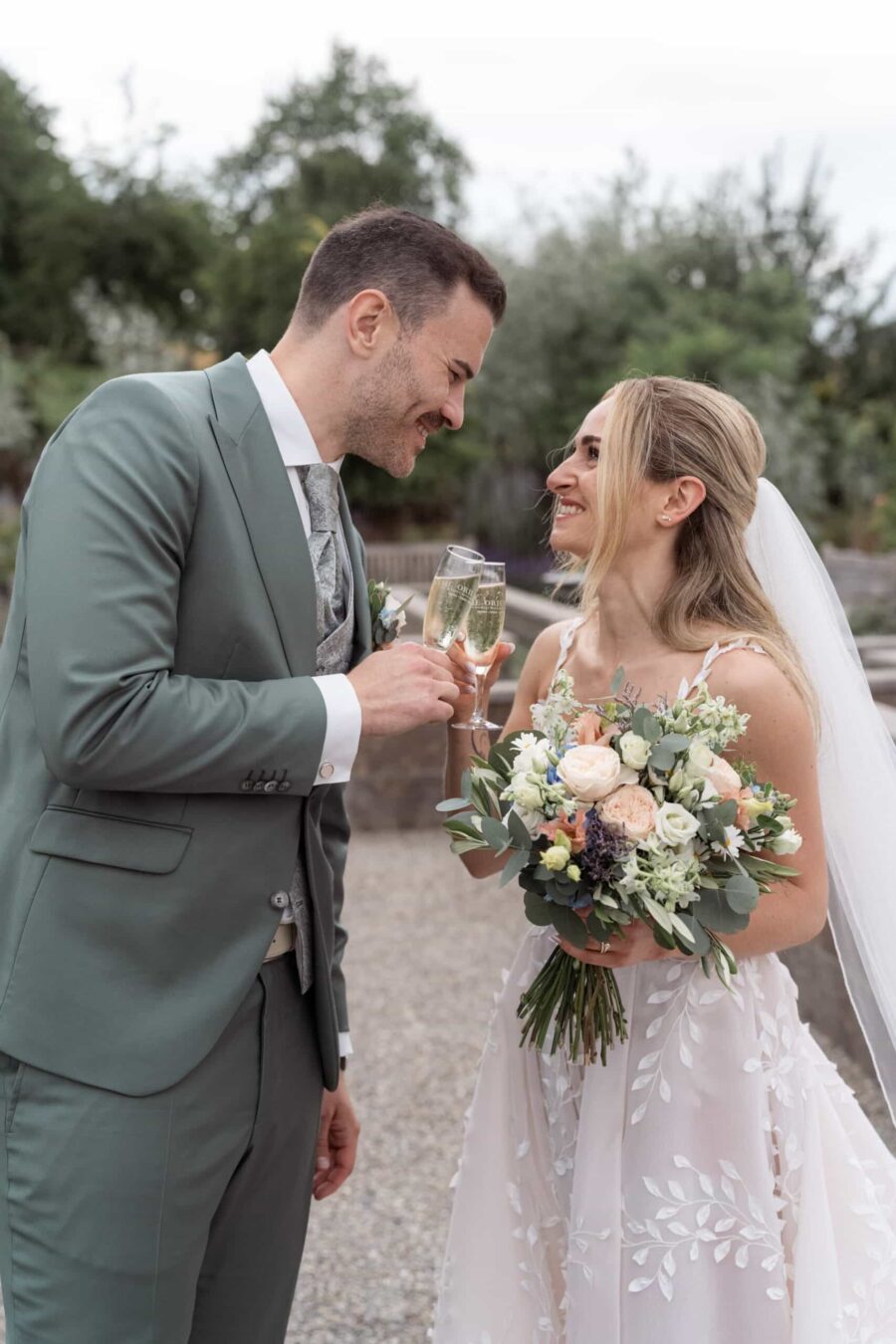 Brautpaar stößt mit Sekt an im Garten