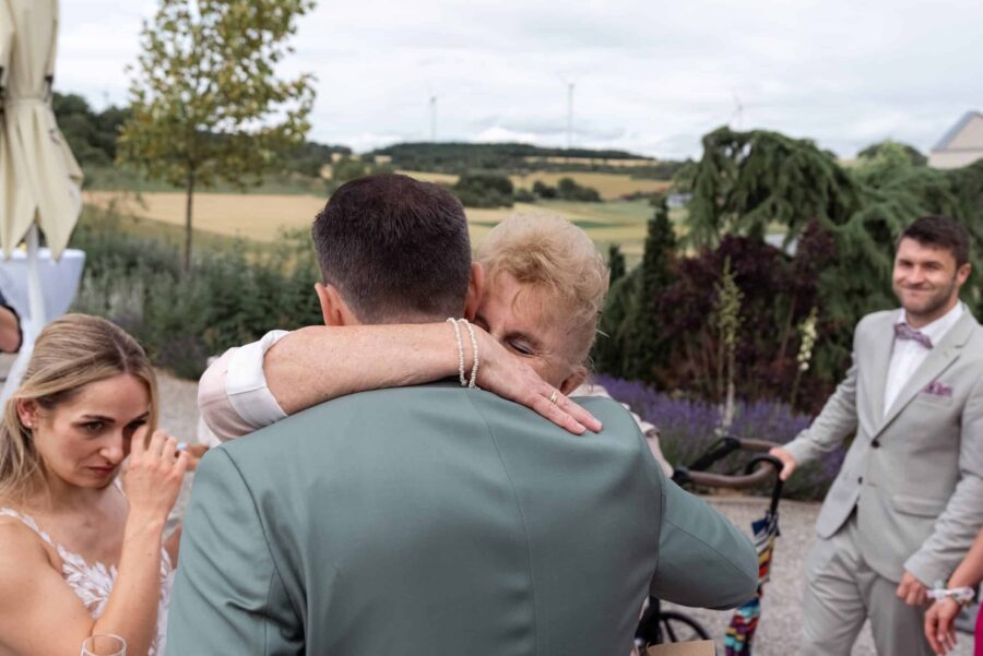 Umarmung im Garten während der Hochzeit feiern.