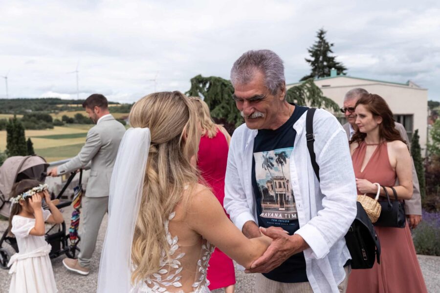 Gäste begrüßen Braut im Garten bei Hochzeitsempfang