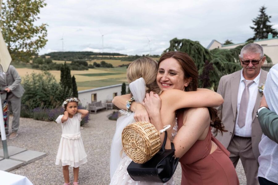 Umarmung bei Hochzeit im Freien.