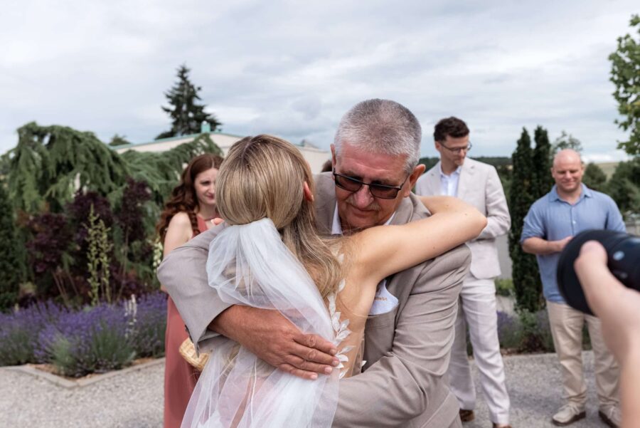 Braut umarmt Gast im sommerlichen Garten