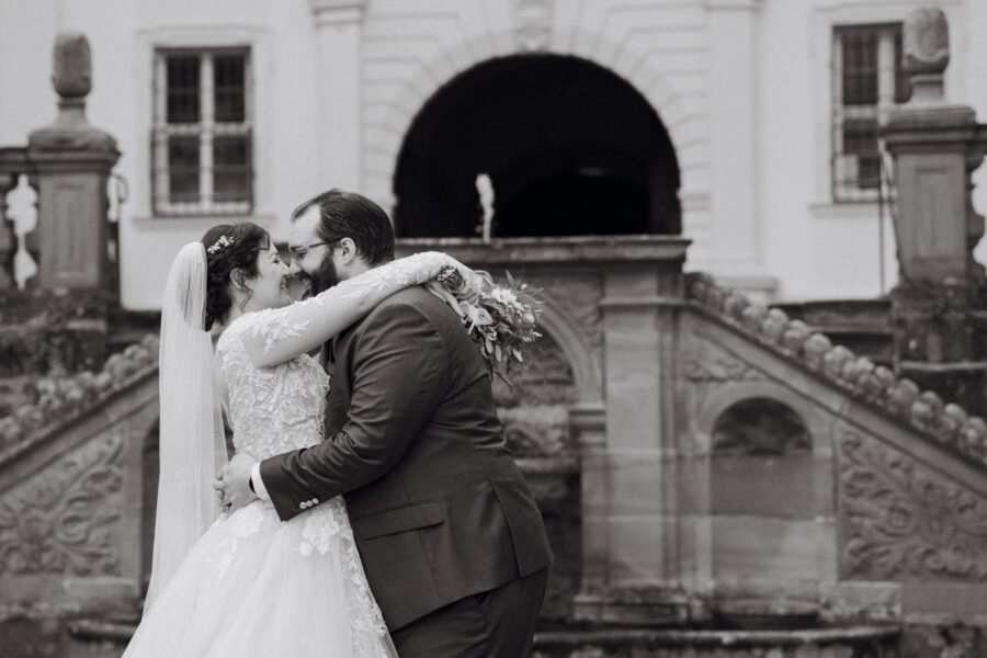 Brautpaar umarmt sich vor historischer Kulisse