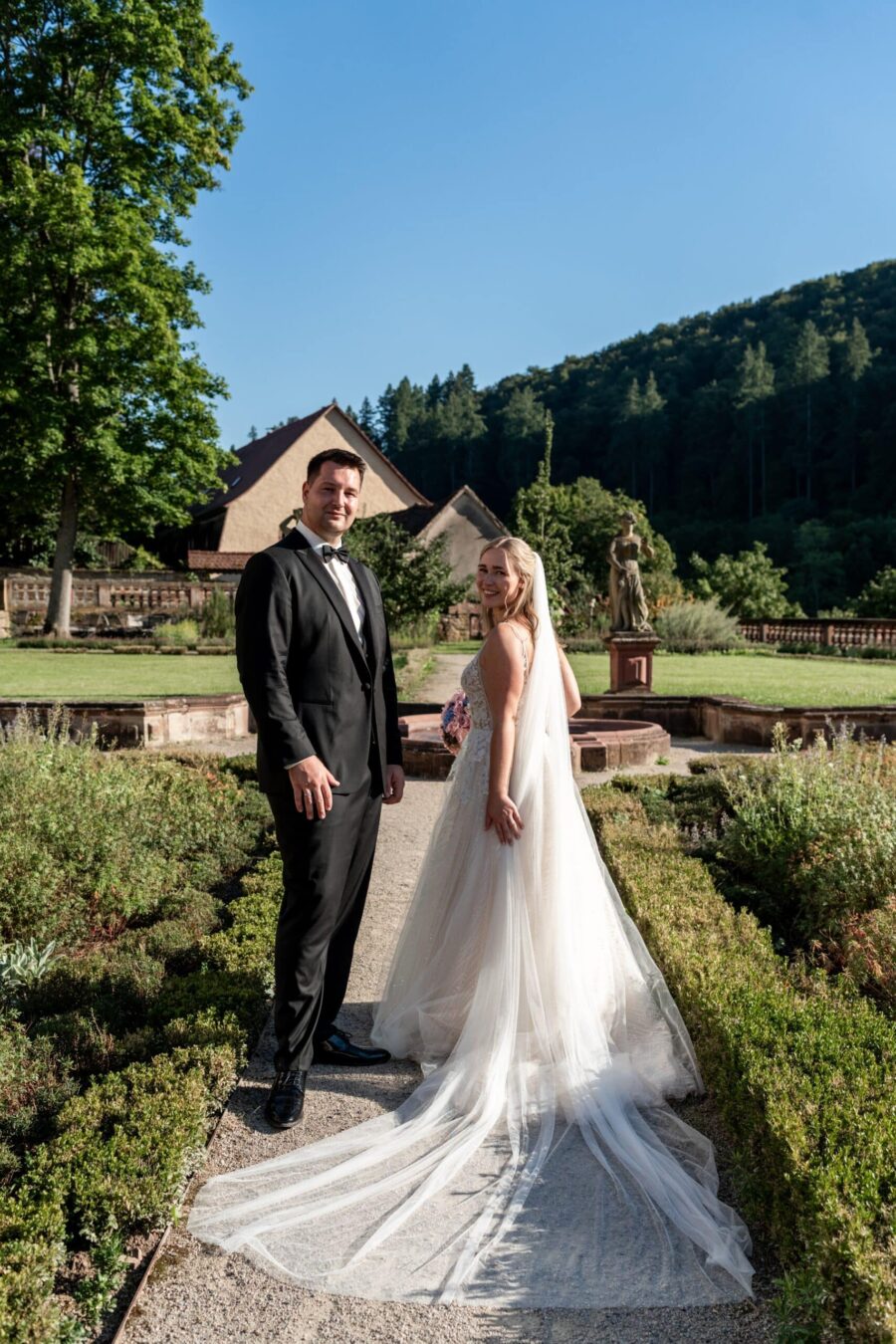Brautpaar im Garten vor Landhaus und Wald