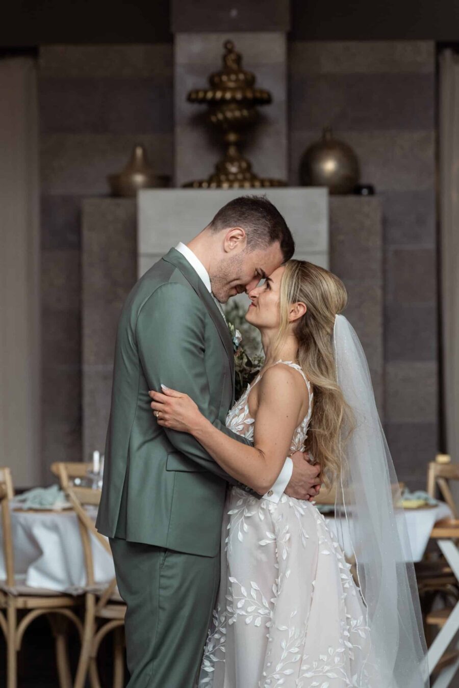 Brautpaar umarmt sich vor Hochzeitstafel