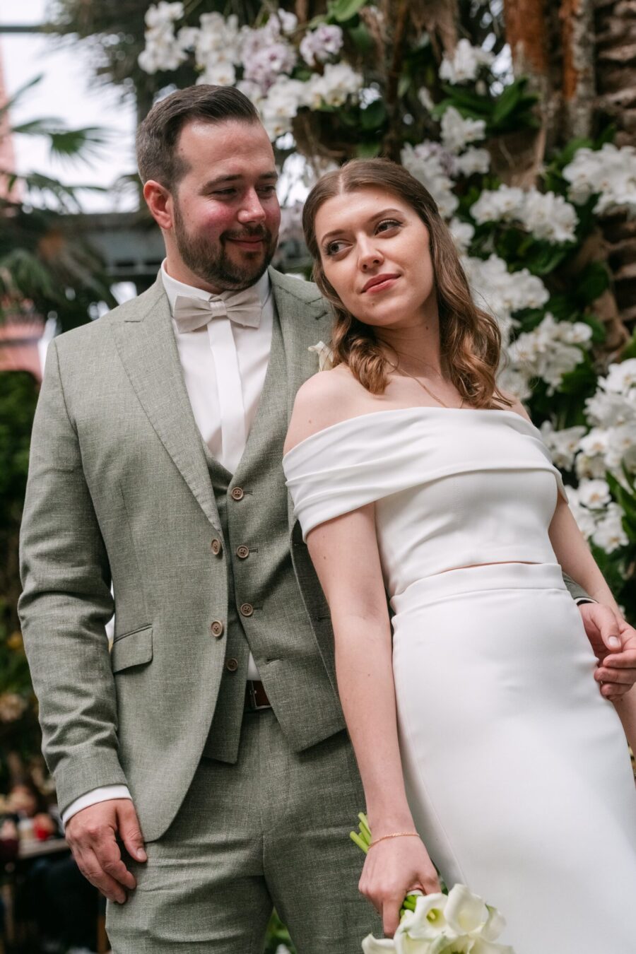 Hochzeit Insel Mainau Bodensee – Heiraten am Bodensee 105 Brautpaar im Gewächshaus vor Orchideen, Braut mit Callas