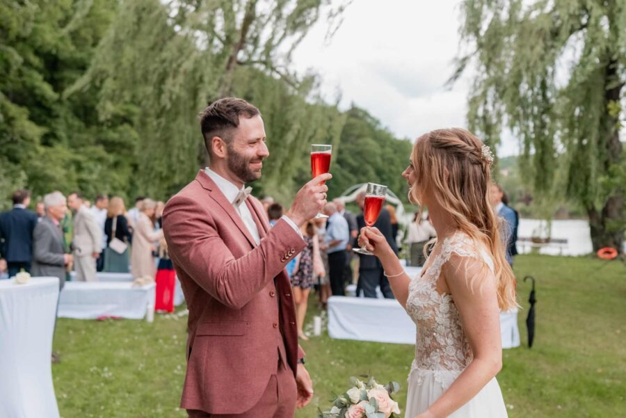 Hochzeitstoast des Paares im Garten mit Gästen