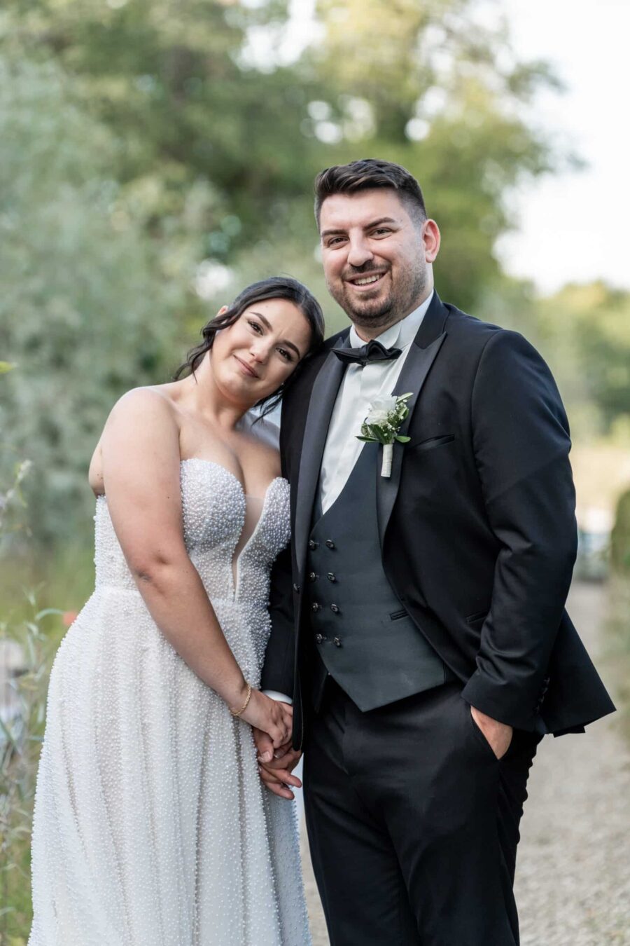 Brautpaar lächelt im Freien bei Hochzeit im Sommergarten