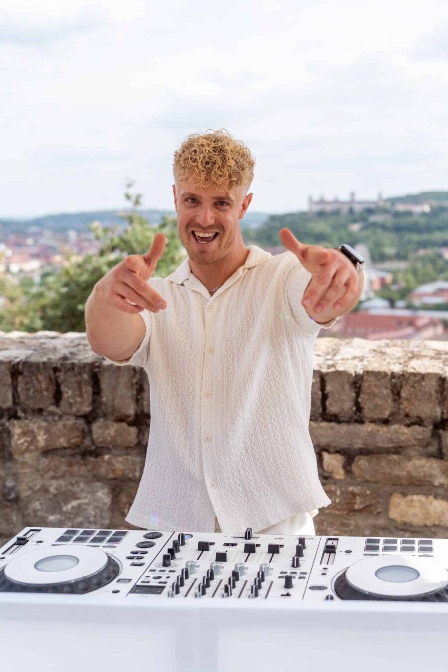 DJ mit Mischpult bei einer Hochzeit im Freien.