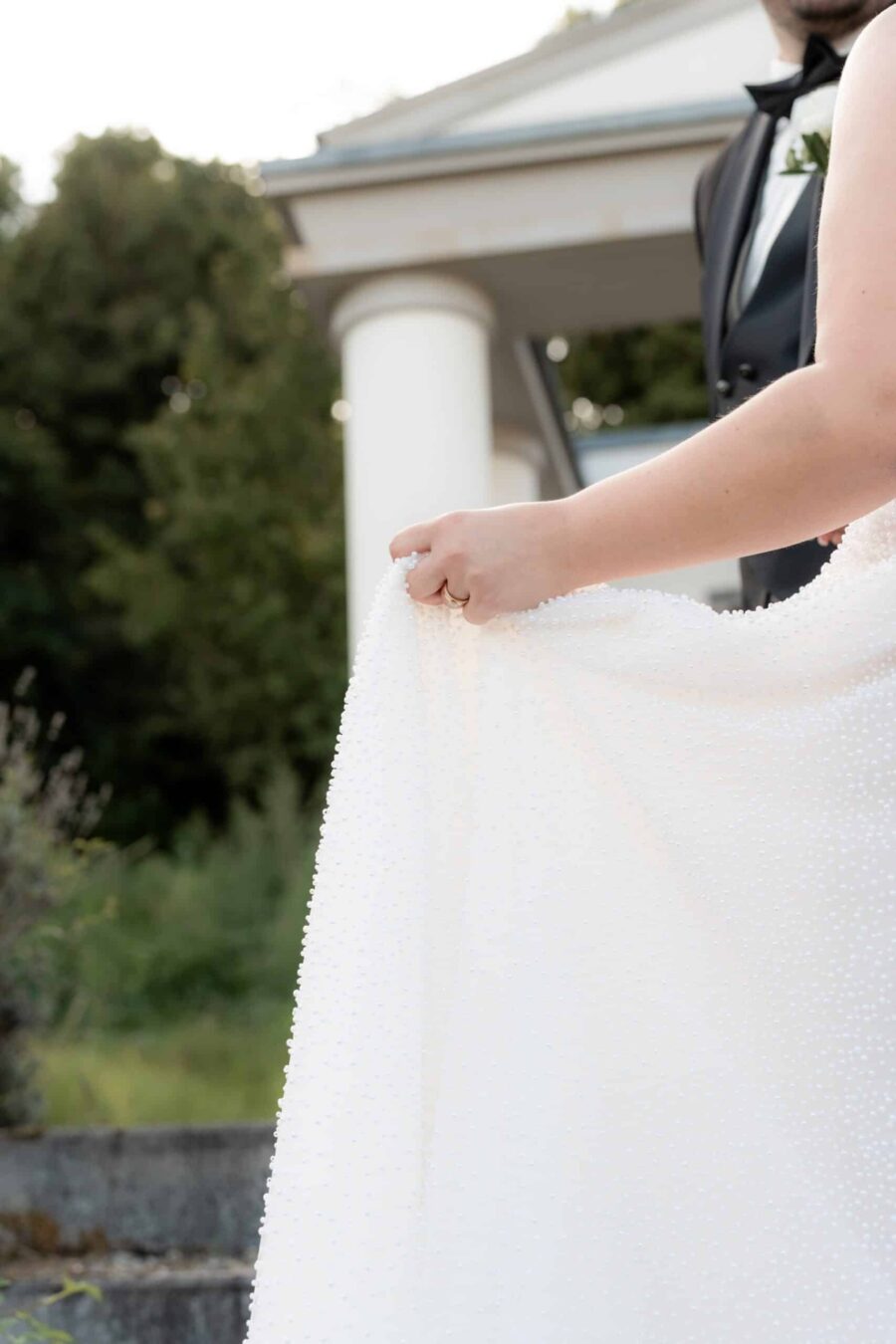 Braut in weißem Kleid vor Säulengebäude