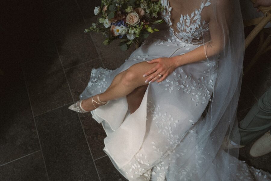 Braut im weißen Kleid mit Blumenstrauß