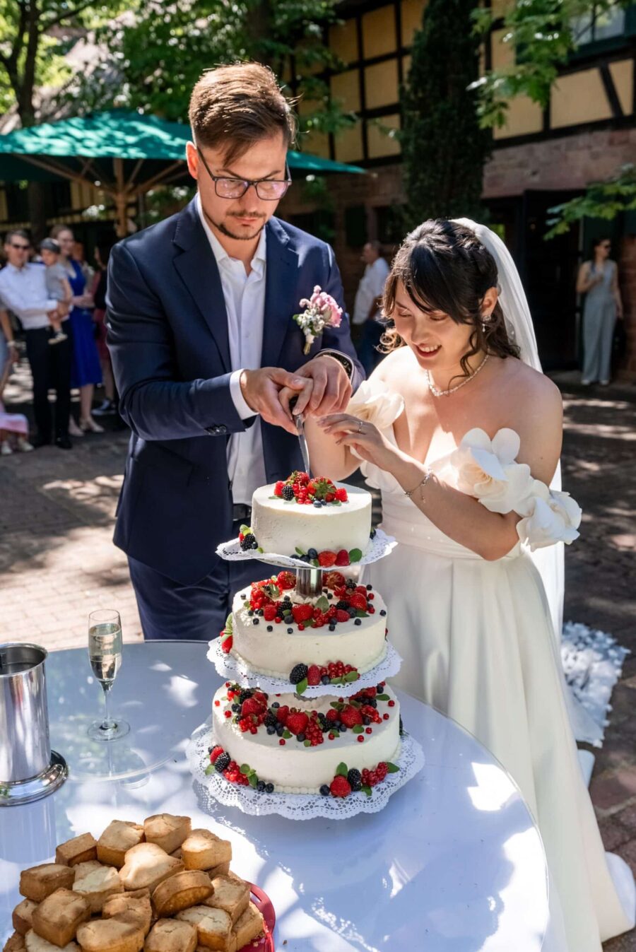 Brautpaar schneidet Hochzeitstorte im Garten, Hofgut Hünersdorff
