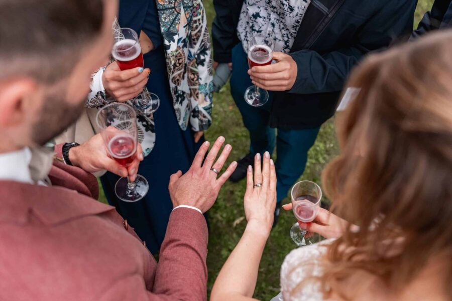 Hände mit Eheringen und Sektgläser bei Hochzeit