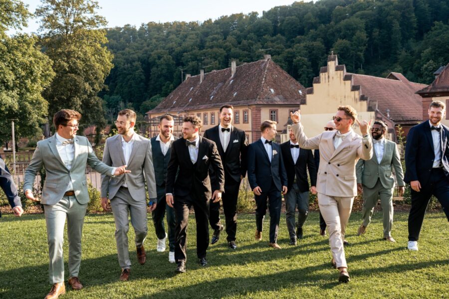 gruppenbilder hochzeit organisieren Gäste in eleganter Kleidung im Gartenensemble