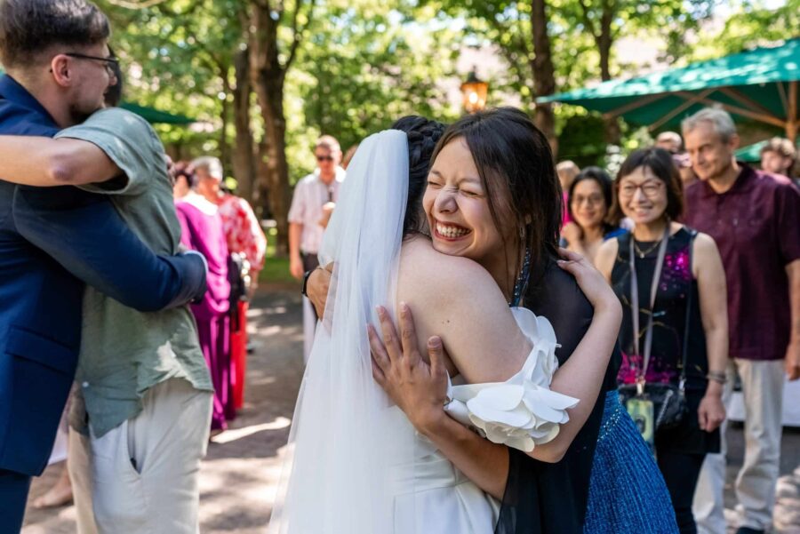 Umarmung der Hochzeitsgäste im Gartenbereich. Hofgut Hünersdorff