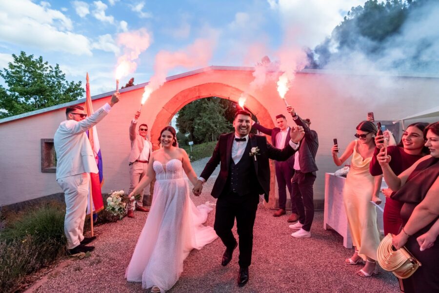 Brautpaar feiert mit roten Fackeln im Freien