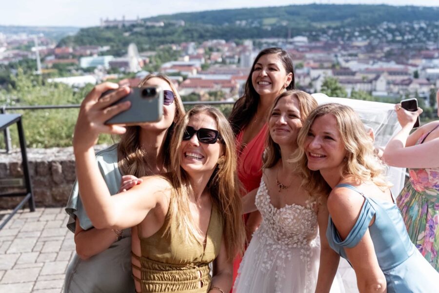 Hochzeit Steinburg Würzburg | Editorial Style & Party | Florian Knusper 54 Gruppe lächelnder Frauen bei Hochzeitsselfie im Freien