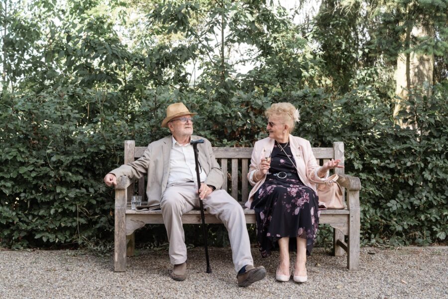 Älteres Paar auf Bank im Garten sitzend