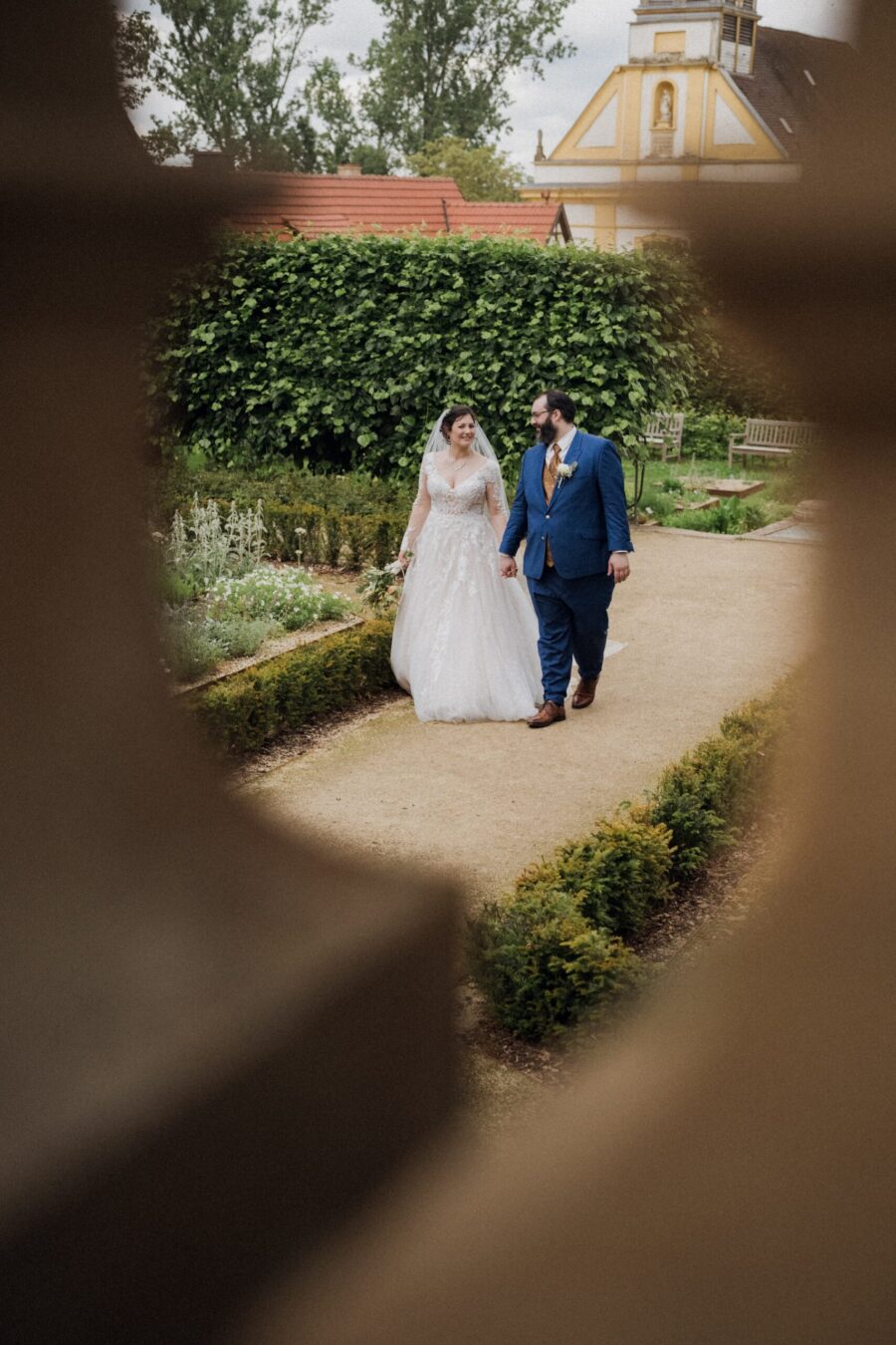 Brautpaar spaziert im Garten einer Villa