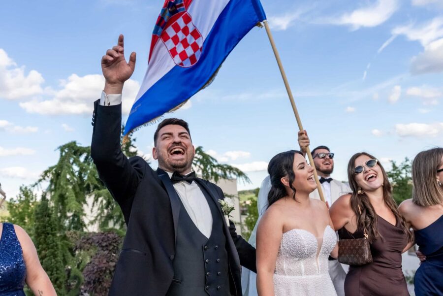 Gäste feiern mit kroatischer Flagge im Freien