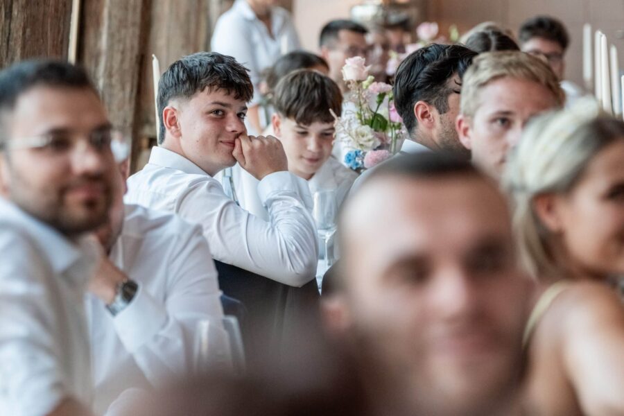 Hochzeitsgäste sitzen bei der Feier am Tisch.