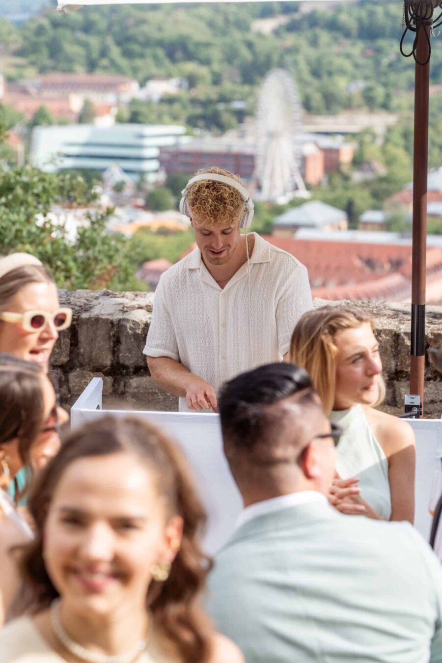 DJ spielt Musik auf Hochzeit im Freien mit Gästen.