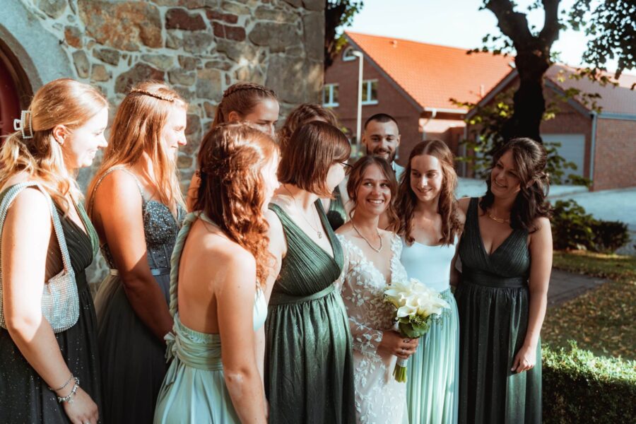 Braut mit Freundinnen vor Natursteinwand