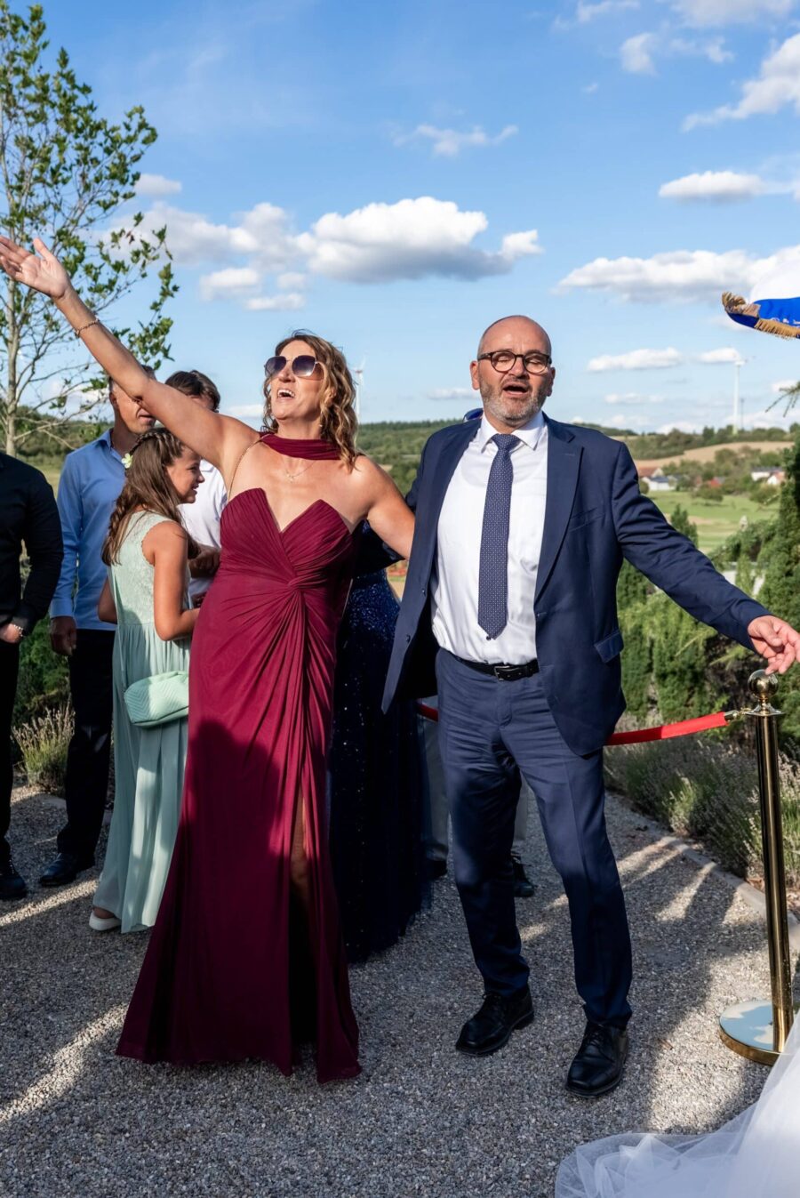 Gäste feiern im Freien bei Hochzeitsempfang.