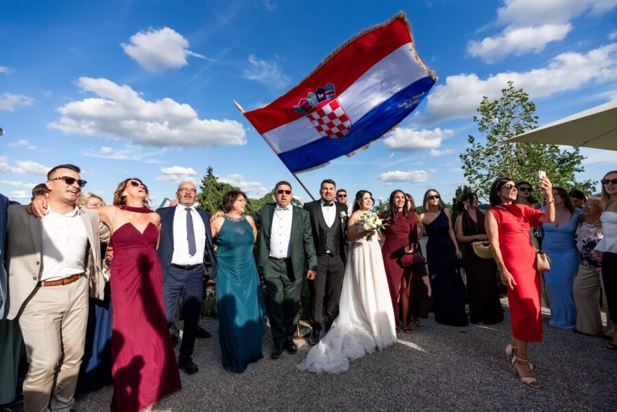 Hochzeitsgesellschaft tanzt mit kroatischer Flagge draußen