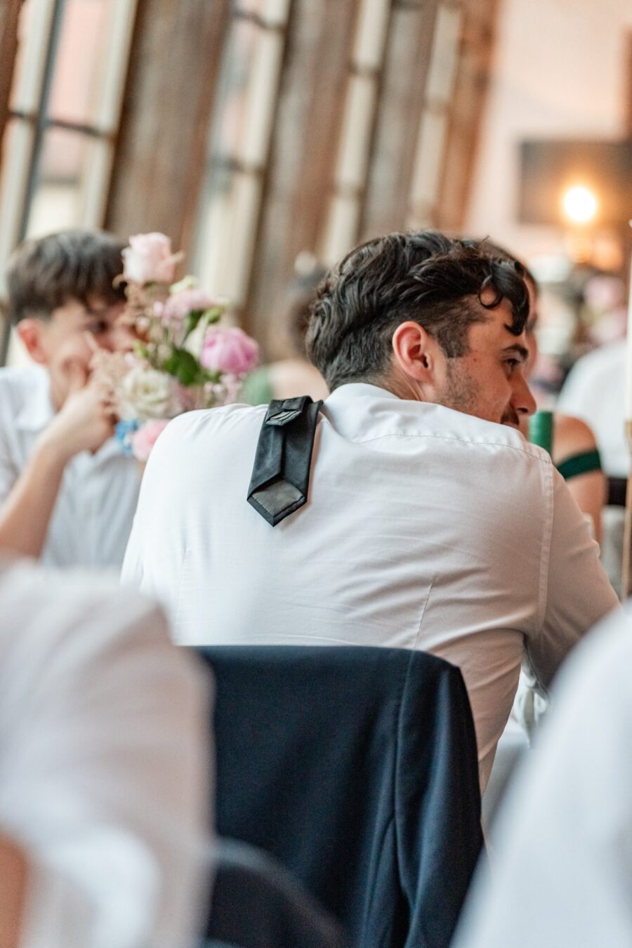Gäste bei Hochzeitsfeier am Tisch sitzend