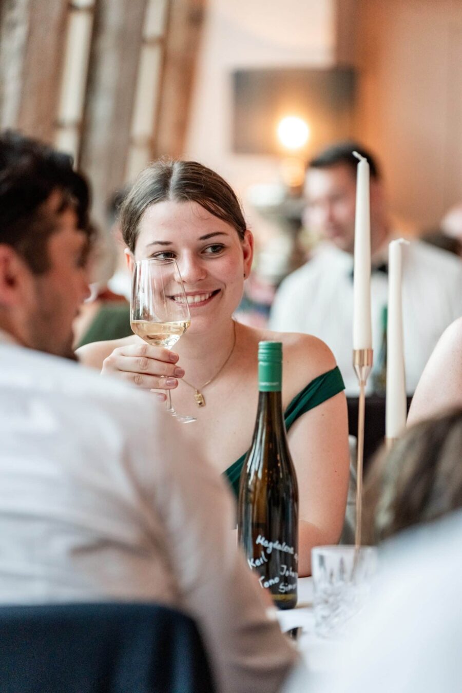Gästetisch mit Wein und Kerzen bei Hochzeitsfeier