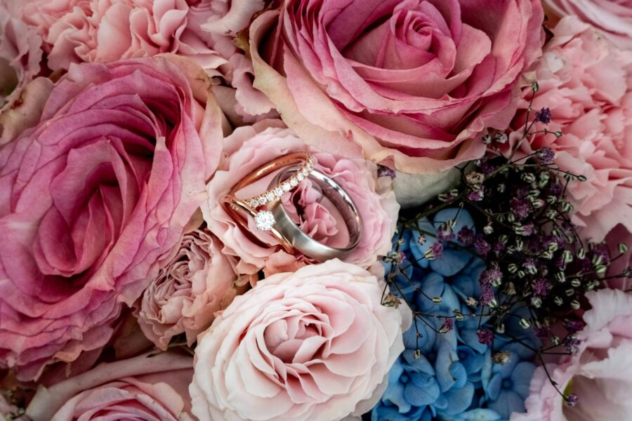 Eheringe auf Rosenblütenarrangement