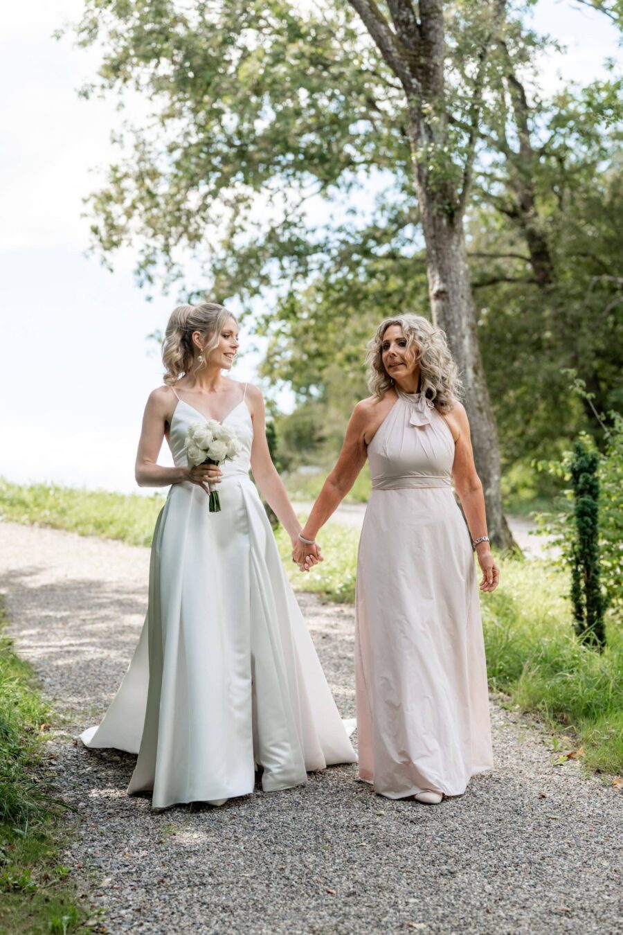 Hochzeit Villa Oriental | Editorial Summer Vibes & Live Cooking 94 Braut mit Begleitung auf Gartenweg