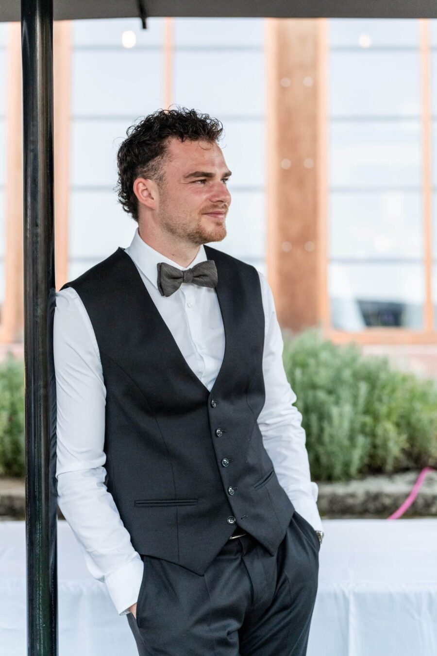 Bräutigam posiert lässig unter Pavillon