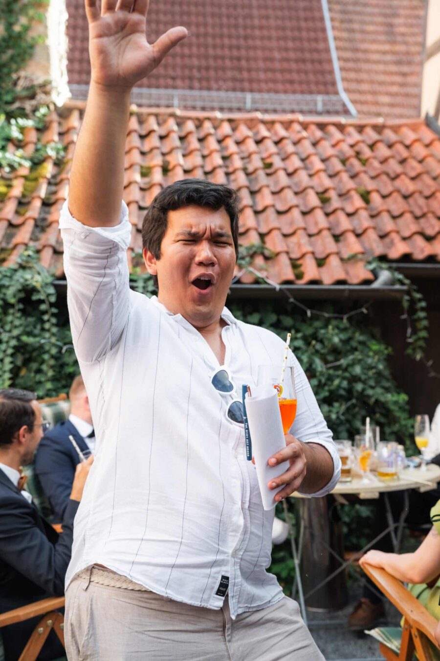 Gäste feiern mit Drinks im Innenhof.
