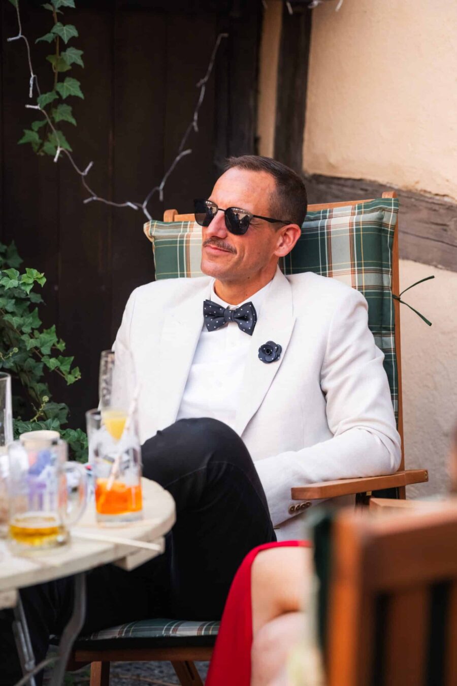 Gast im Anzug entspannt bei Gartenhochzeit